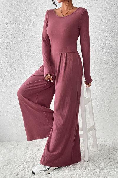 a woman in a long sleeved jumpsuit posing for the camera