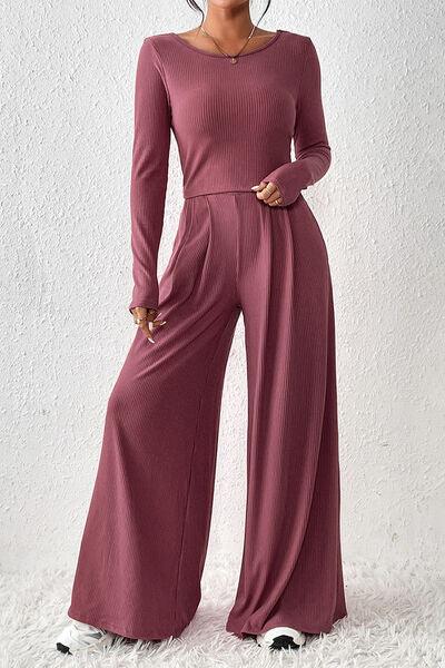 a woman in a pink sweater and wide legged pants