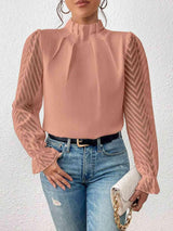 a woman wearing a pink blouse and jeans