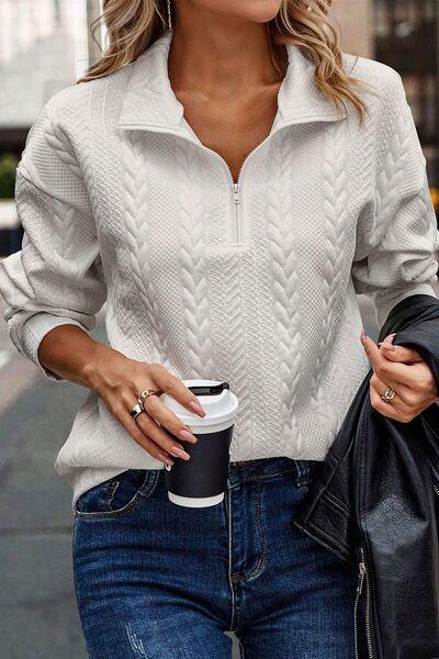 a woman wearing a white sweater and jeans