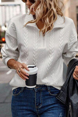 a woman walking down the street with a cup of coffee in her hand