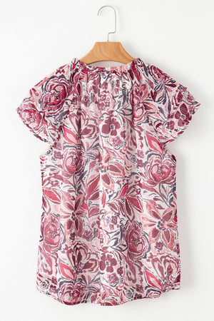 a pink blouse hanging on a wooden hanger