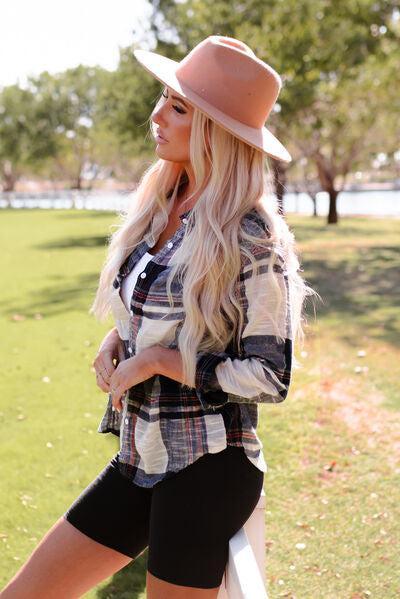 a woman wearing a hat and a plaid shirt