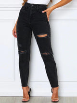 a woman wearing black ripped jeans and heels