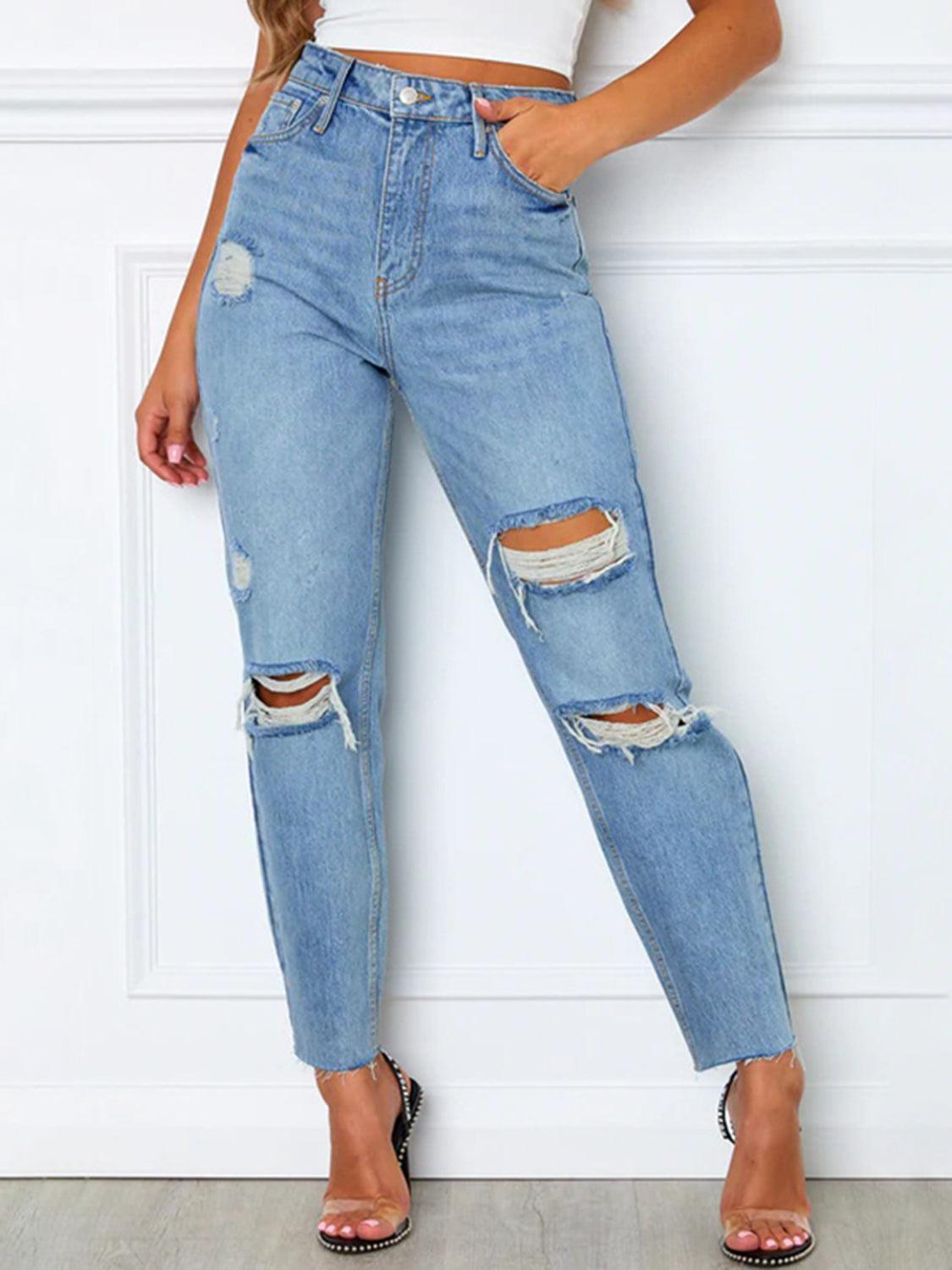 a woman wearing ripped jeans and a crop top