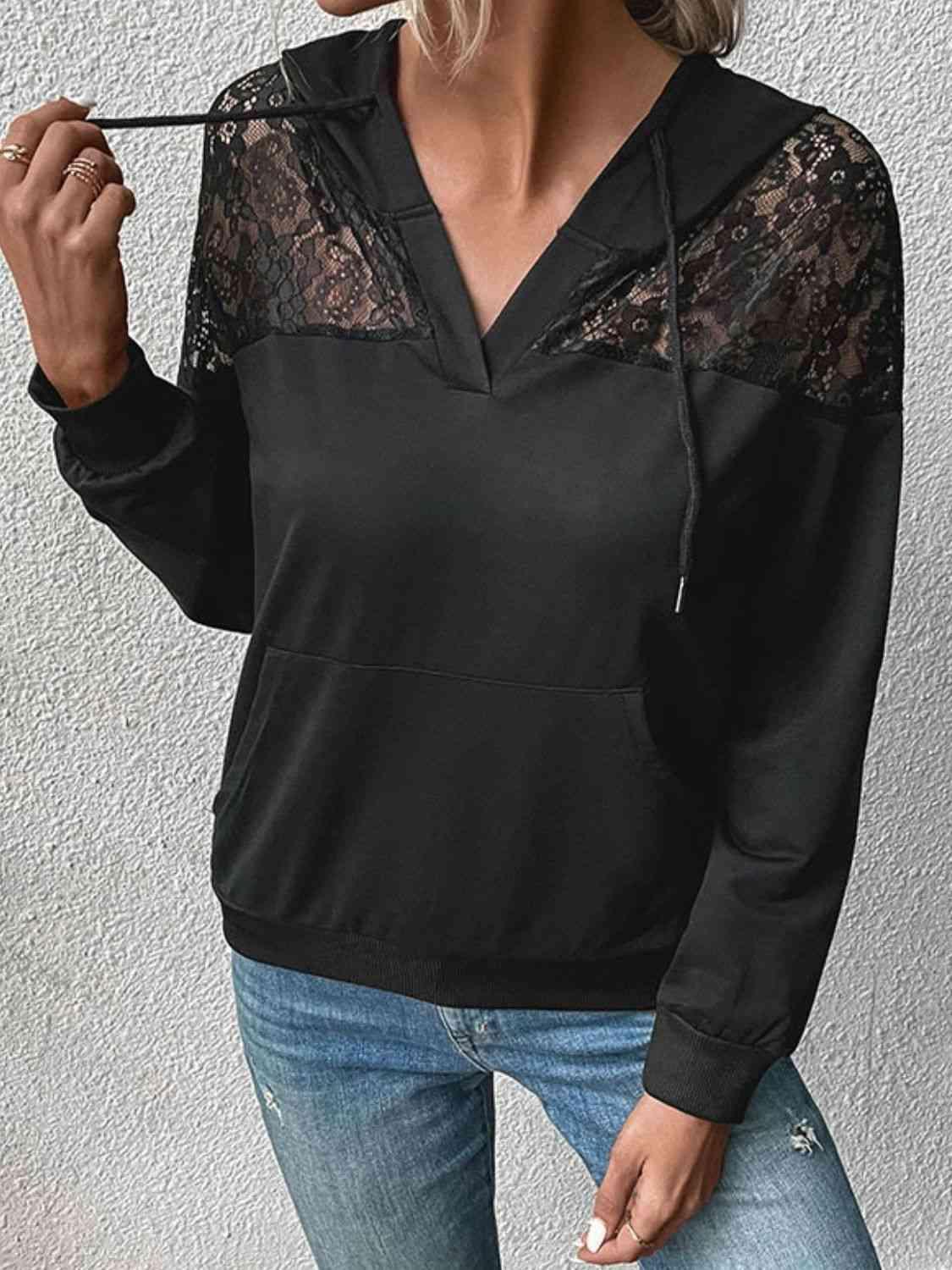 a woman wearing a black top with lace sleeves