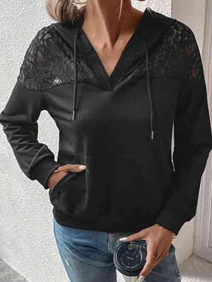 a woman wearing a black hoodie and jeans