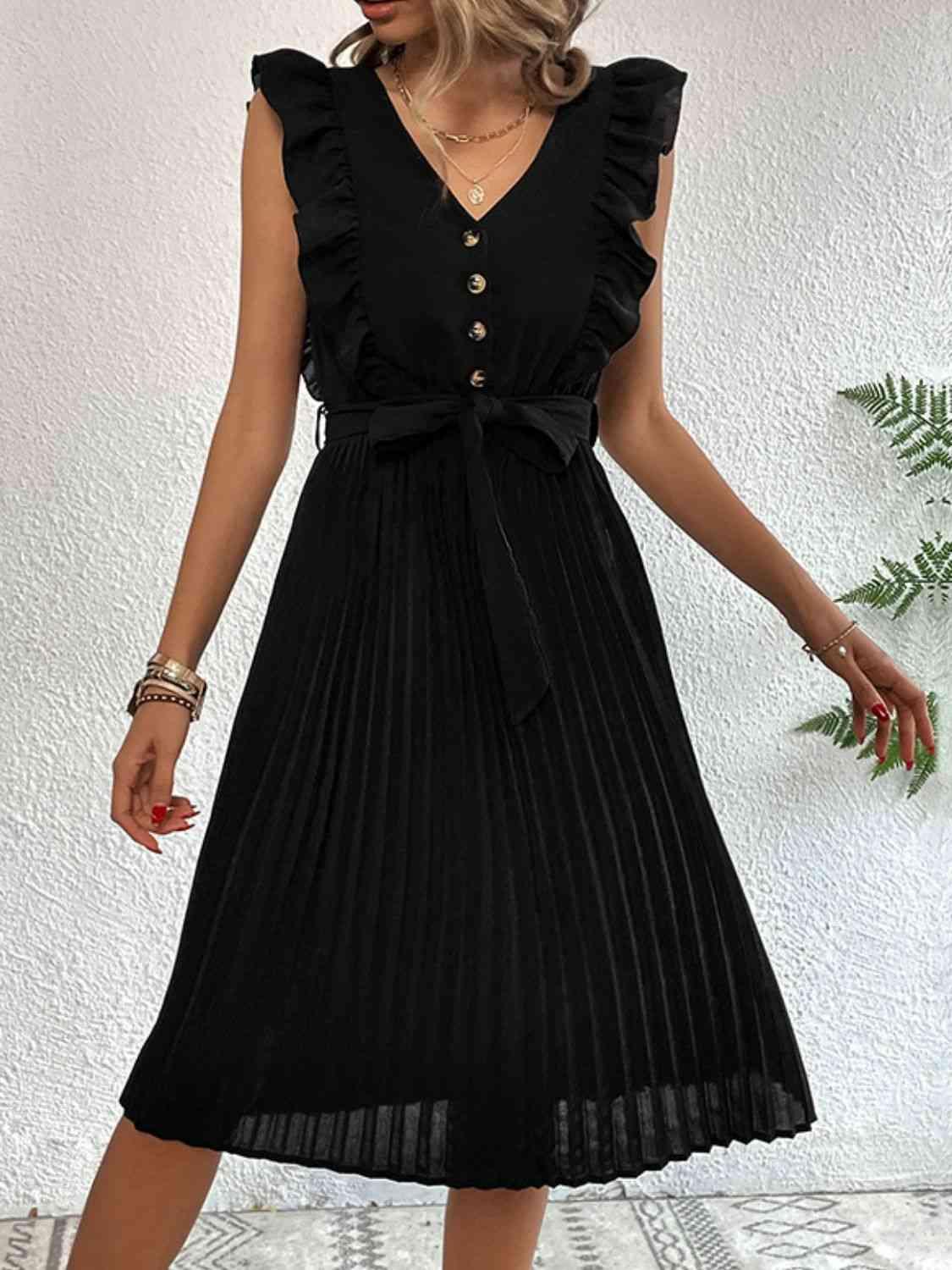 a woman wearing a black dress with a pleated skirt