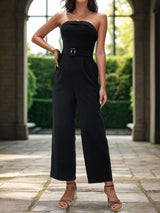 a woman in a strapless jumpsuit posing for a picture