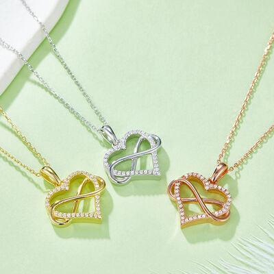 three necklaces with a heart on a green surface