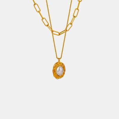a gold necklace with a pearl hanging from it