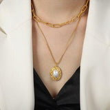 a woman wearing a white jacket and a gold necklace