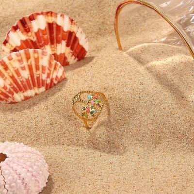 a seashell, a ring, and a seashell on the sand
