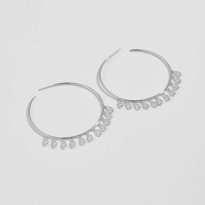 a pair of silver hoop earrings on a white background