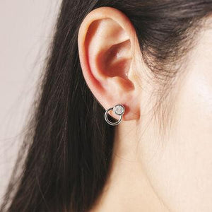 a close up of a person wearing a pair of earrings