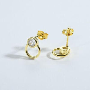 a pair of gold earrings with a single diamond