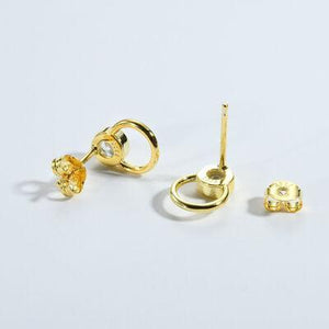 a pair of gold earrings on a white background