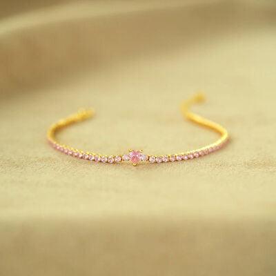 a gold bracelet with pink stones on it