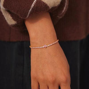 a woman's hand wearing a bracelet with pink stones