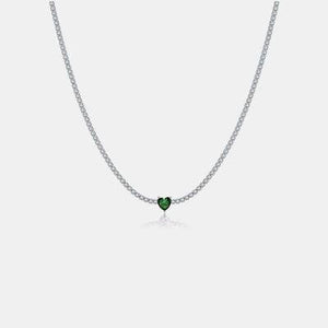 a necklace with a heart shaped green stone