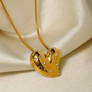 a gold heart shaped pendant on a gold chain