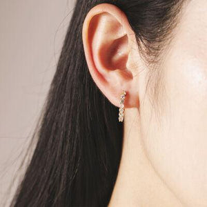 a close up of a person wearing a pair of earrings