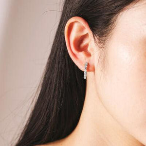 a close up of a person wearing a pair of earrings