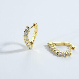 a pair of yellow gold earrings on a white background