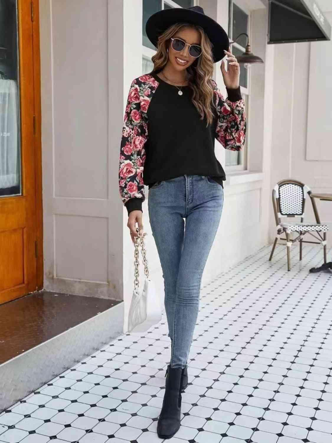 a woman walking down a sidewalk wearing a hat and jeans