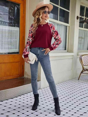a woman wearing a red top and jeans