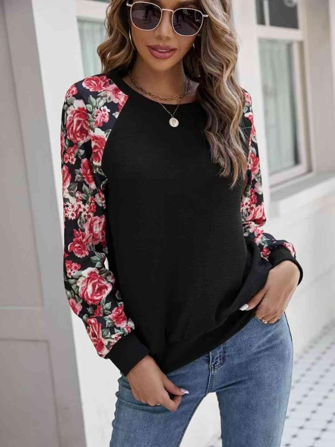 a woman wearing a black and floral top
