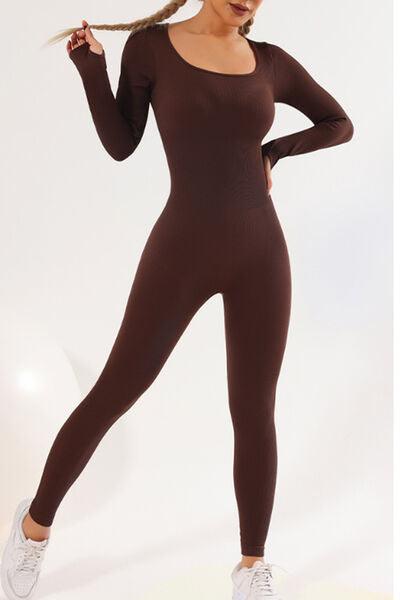 a woman in a brown bodysuit posing for a picture