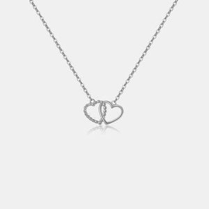 a necklace with two hearts hanging from it