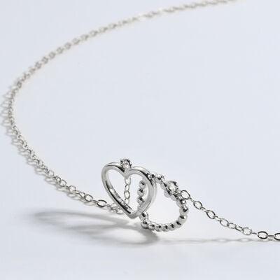 a silver necklace with two hearts on it