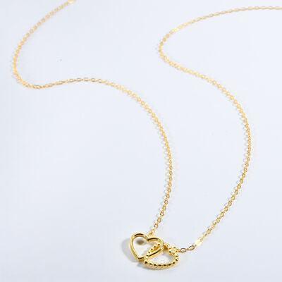 a gold necklace with a heart on it