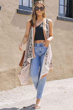 a woman walking down a street wearing a tank top and cardigan