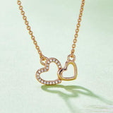 a gold necklace with two hearts hanging from it