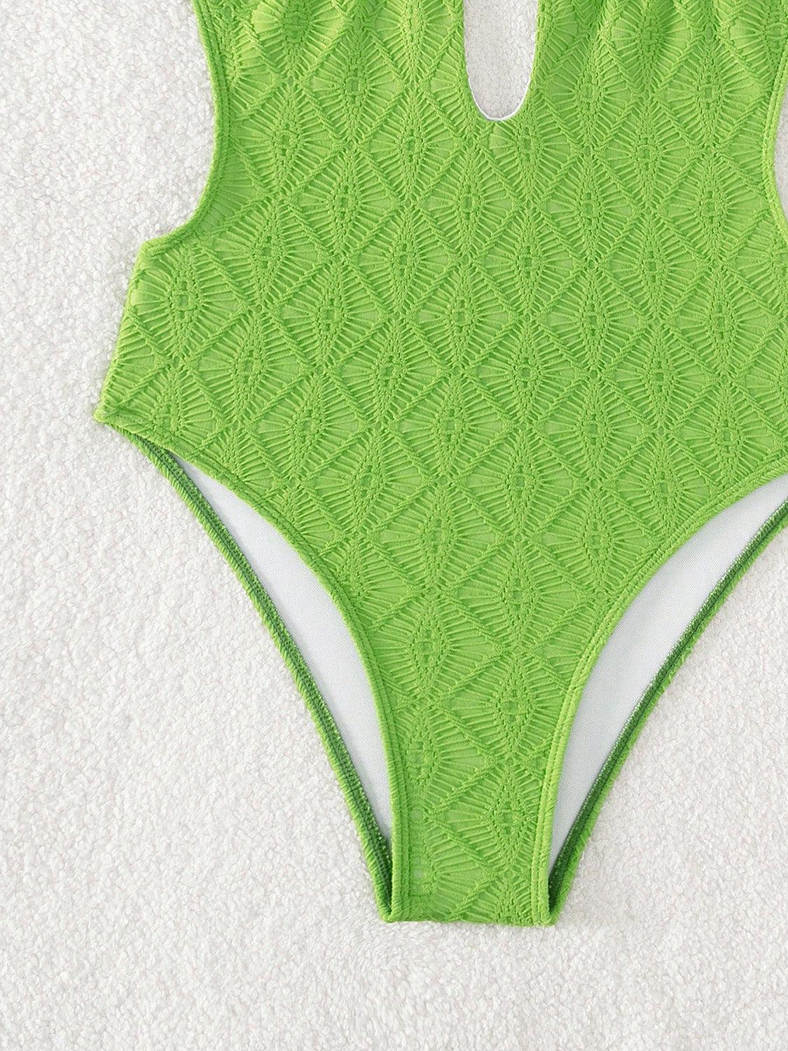 a woman's green swimsuit on a white towel