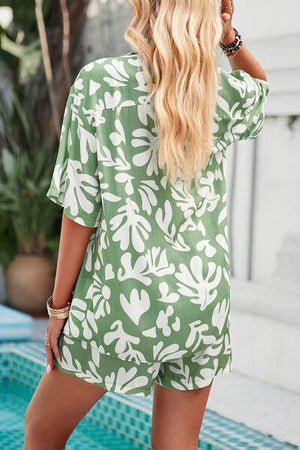 a woman standing in front of a pool wearing a green and white floral print rom