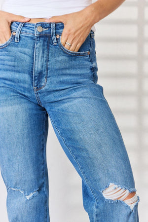 a woman in ripped jeans is holding her stomach