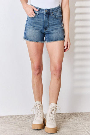 a woman wearing a white shirt and denim shorts