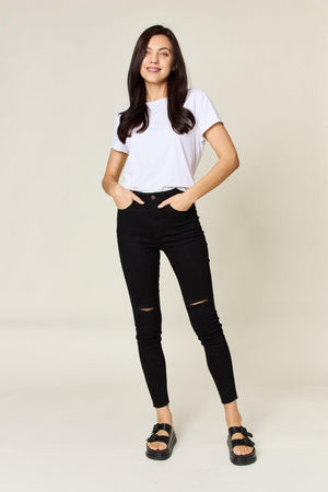a woman posing for a picture in a white shirt and black jeans