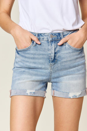 a woman wearing a white shirt and denim shorts