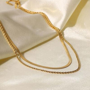 a close up of a gold necklace on a white cloth