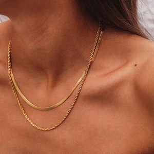 a close up of a woman wearing a gold necklace