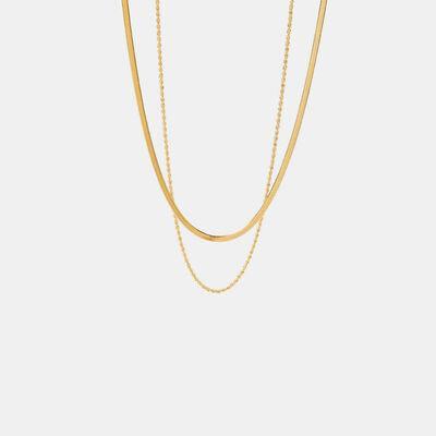 a gold necklace with a chain on a white background