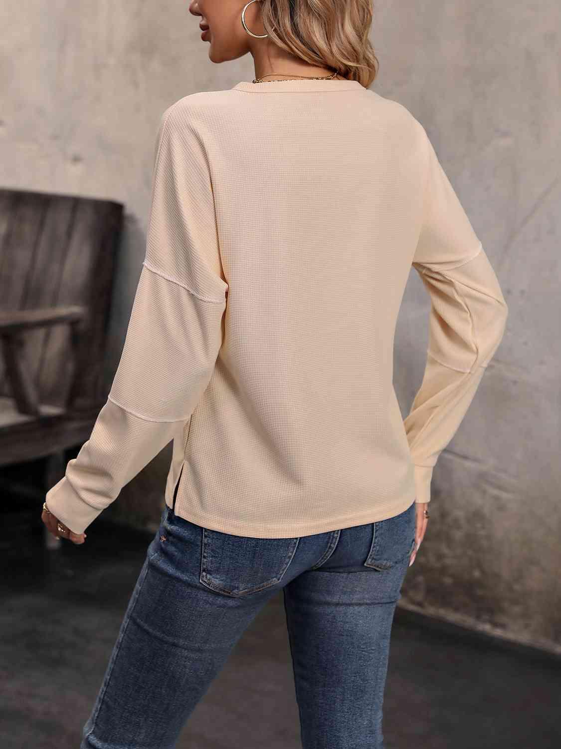 a woman wearing a beige sweater and jeans