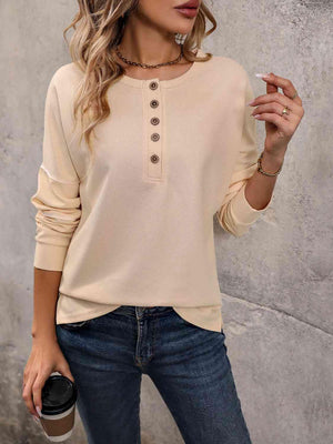 a woman wearing a beige sweater and jeans