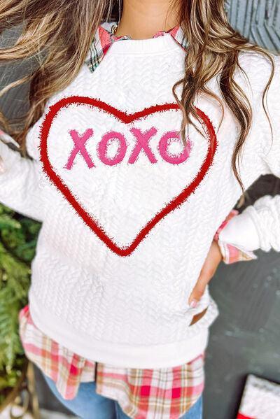 a woman wearing a sweater with a heart drawn on it