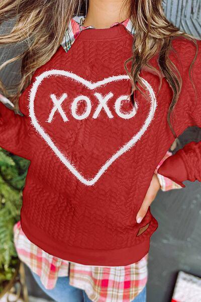 a woman wearing a red shirt with a heart drawn on it